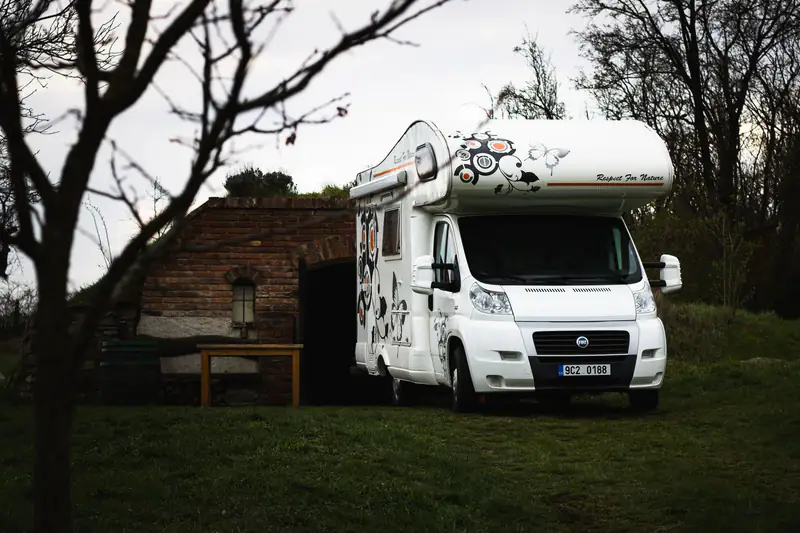 Alkoven kamper na bazi Fiat Ducato parkiran u dvorištu