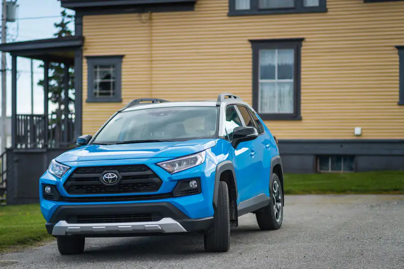 Plava Toyota RAV4 pete generacije parkirana ispred kuće
